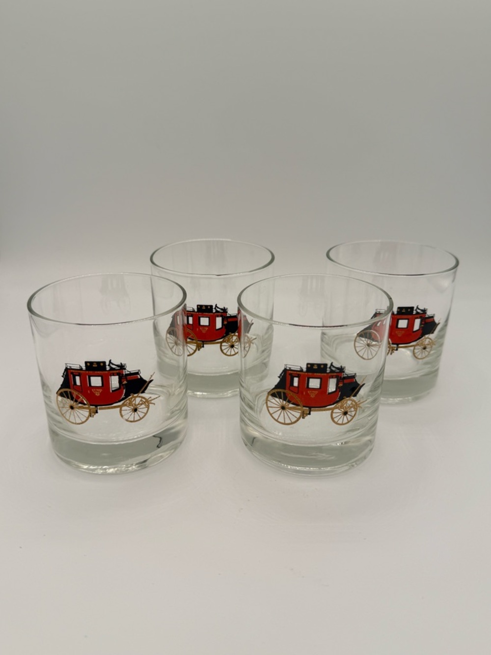 Set of 4 vintage glasses featuring Wells Fargo stagecoach design.